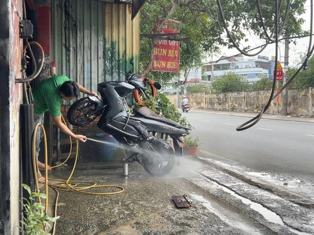 The vehicle washing shop is less than one meter from the street. Photo: An Vi / Tuoi Tre