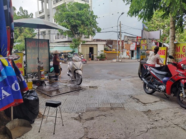 Roadside vehicle washing shops bother road users. Photo: Song Khue / Tuoi Tre