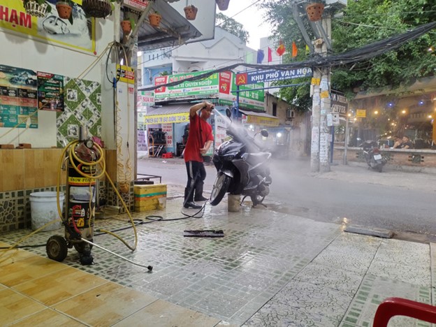 Dirt and wastewater from a vehicle washing shop on Nguyen Tu Gian Street in Go Vap District, Ho Chi Minh City splash onto the street. Photo: Song Khue / Tuoi Tre