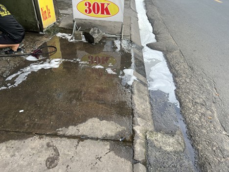 Wastewater from the vehicle washing shop spreads onto the street. Photo: An Vi / Tuoi Tre