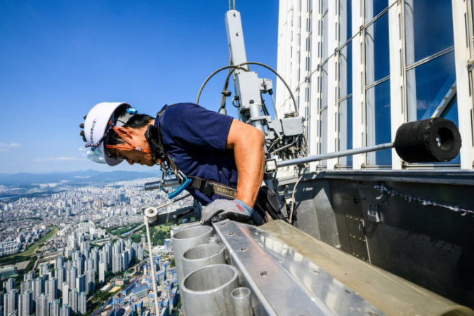 Seo Seung-ho looks down from a special gondola at the Lotte World Tower.