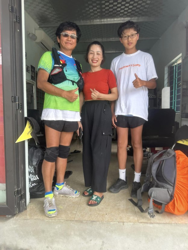 They pose for a photo with a Vietnamese person (C) during their journey. Photo: Supplied