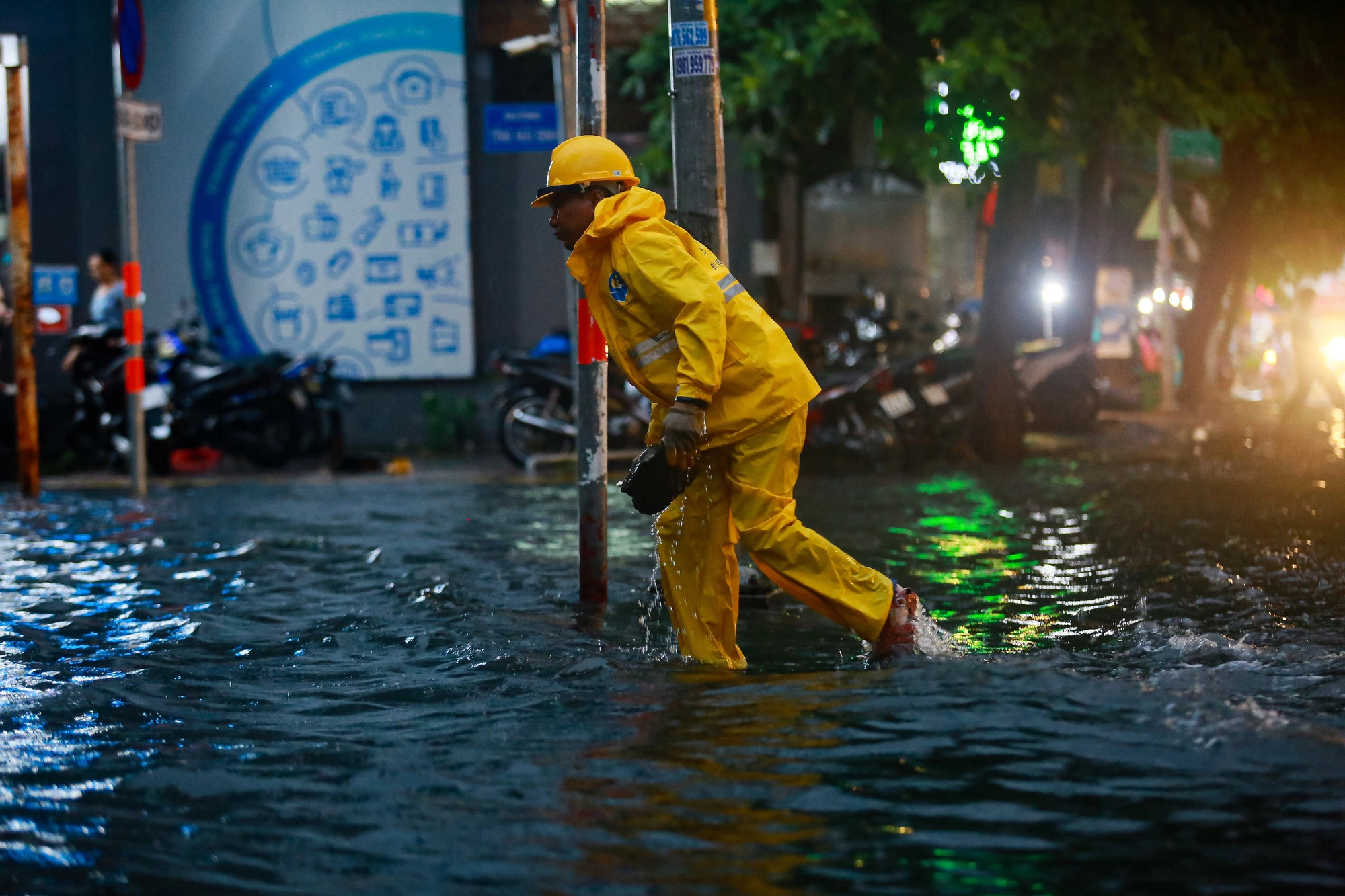 An employee of Ho Chi Minh City Urban Drainage Company removes a stone from a clogged manhole on Quoc Huong Street in Thao Dien Ward, Thu Duc City under Ho Chi Minh City, July 3, 2024. Photo: Chau Tuan / Tuoi Tre