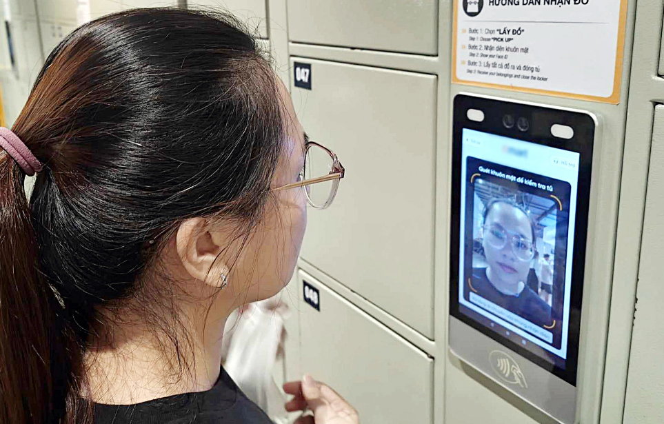 A woman takes the face verification step to use a storage cabinet at a supermarket in Ho Chi Minh City. Photo: Duc Thien / Tuoi Tre