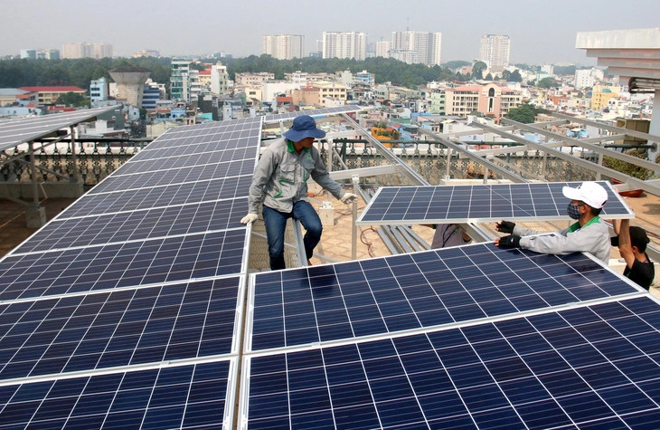 Workers install rooftop solar power panels at a building in Vietnam. Photo: TTO