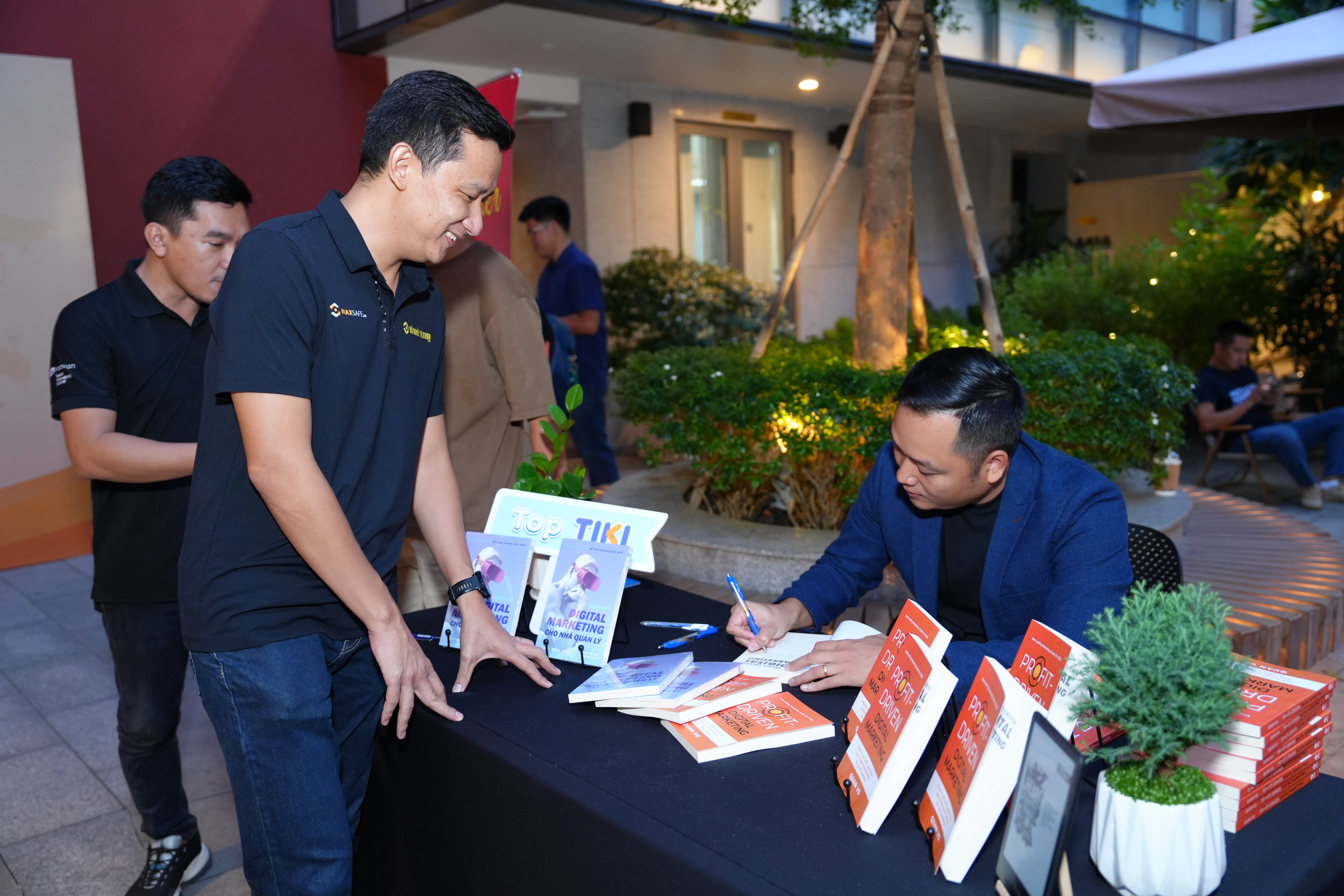 Quan Vo signs copies of his book and gives them to guests at the ‘Journey of Exporting Knowledge’ talk show held in Ho Chi Minh City on July 5, 2024. Photo: Supplied