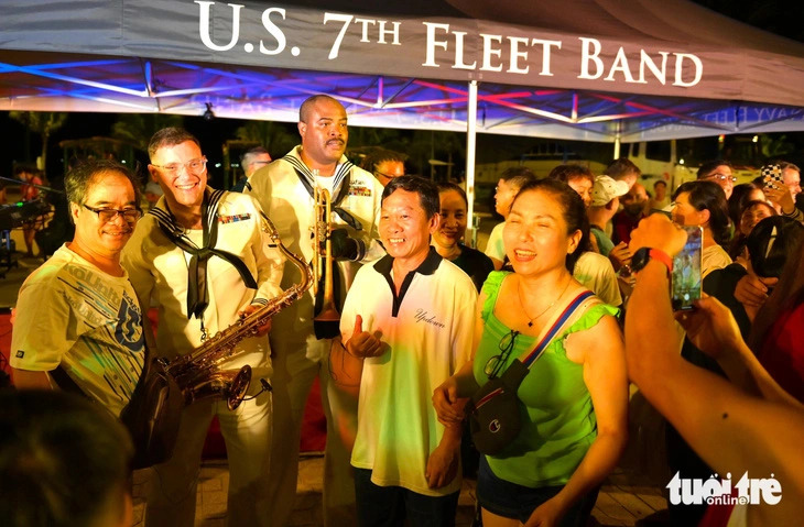 Some members of the USS Blue Ridge troupe (L) and locals pose for a photo during their performance at Tue Tinh Park in Nha Trang City, Khanh Hoa Province, south- central Vietnam on July 8, 2024. Photo: Nguyen Hoang / Tuoi Tre