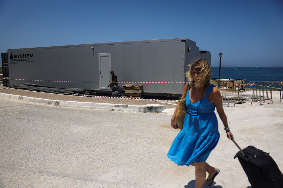 [8/10]A tourist walks past a desalination plant, on the island of Naxos, Greece, June 20, 2024. Photo: Reuters