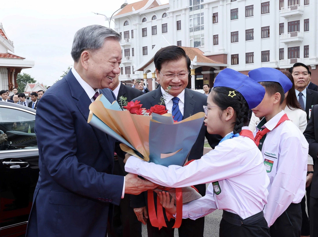 Vietnam’s State President To Lam received flowers presented by a Laotian little girl at Wattay International Airport in Vientiane, Laos on July 11, 2024. Photo: VNA