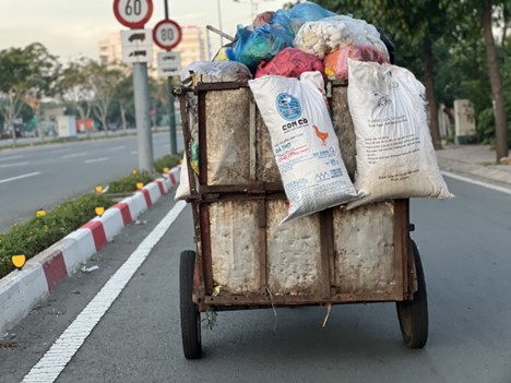 A degraded vehicle full of garbage runs on Pham Van Dong Street in Thu Duc City, under Ho Chi Minh City.