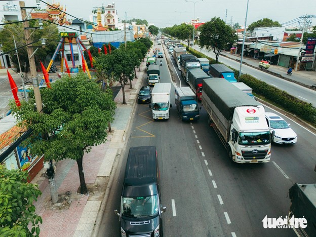 Coaches and trucks queue up to move to the motorbike lane on National Highway 22 in Ho Chi Minh City. Photo: Thanh Hiep / Tuoi Tre