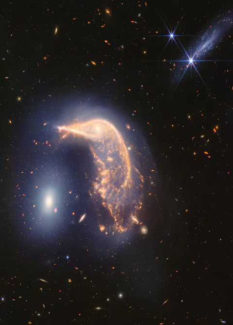 Arp 142, two interacting galaxies, observed in near- and mid-infrared light, are shown in an image obtained by the James Webb Space Telescope, using its Near Infrared Camera (NIRCam) and Mid-Infrared Instrument (MIRI) instruments, released by NASA on July 12, 2014. At left is galaxy NGC 2937, nicknamed the Egg. Its center is brighter and whiter. There are six diffraction spikes atop its gauzy blue layers. At right is galaxy NGC 2936, nicknamed the Penguin. Its beak-like region points toward and above the Egg. The galaxies are approximately the same mass, which is why one hasn?t consumed the other. Photo: Reuters