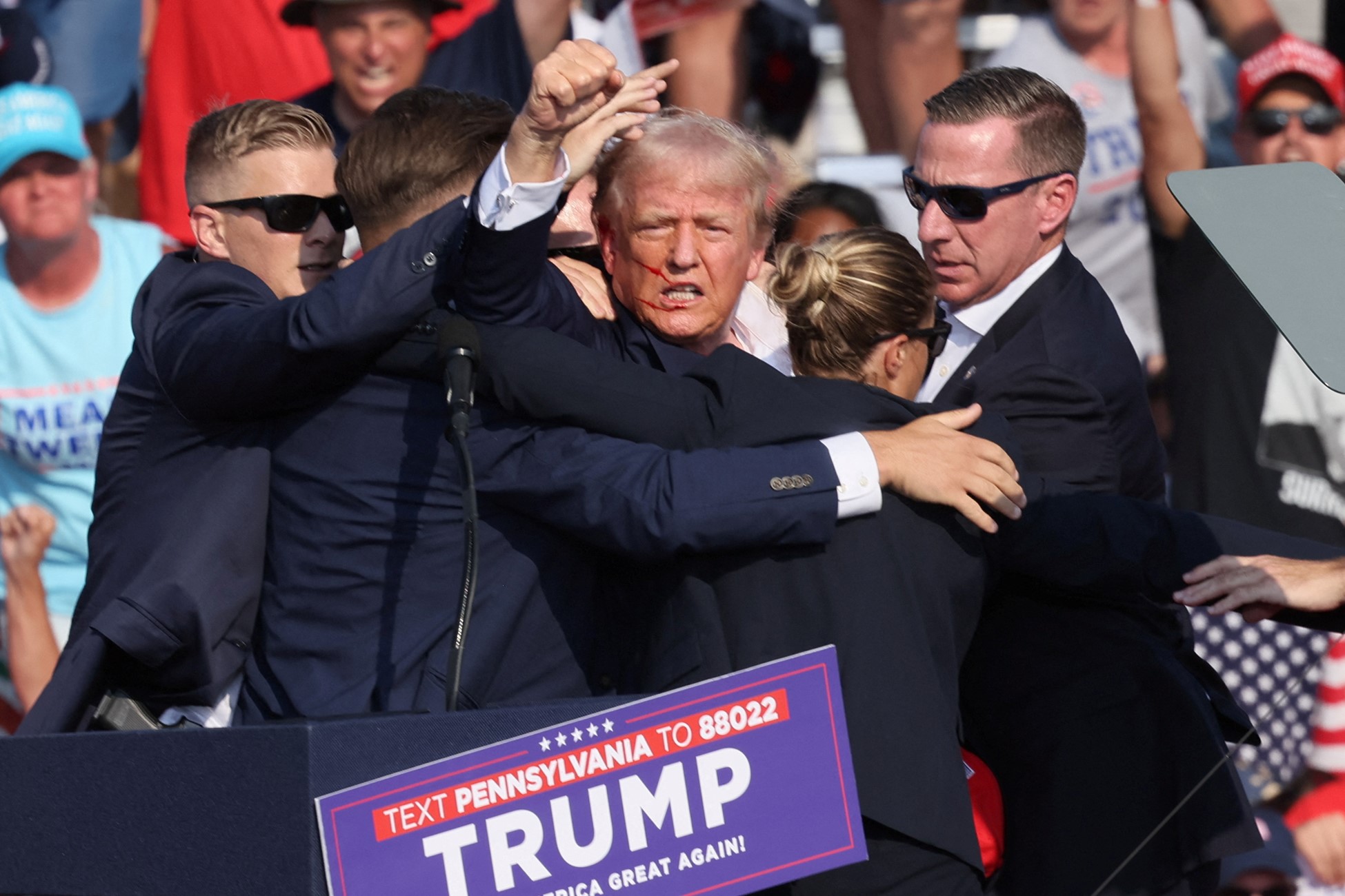 Republican presidential candidate and former U.S. President Donald Trump is assisted by security personnel after gunfire rang out during a campaign rally at the Butler Farm Show in Butler, Pennsylvania, U.S., July 13, 2024. Photo: Reuters