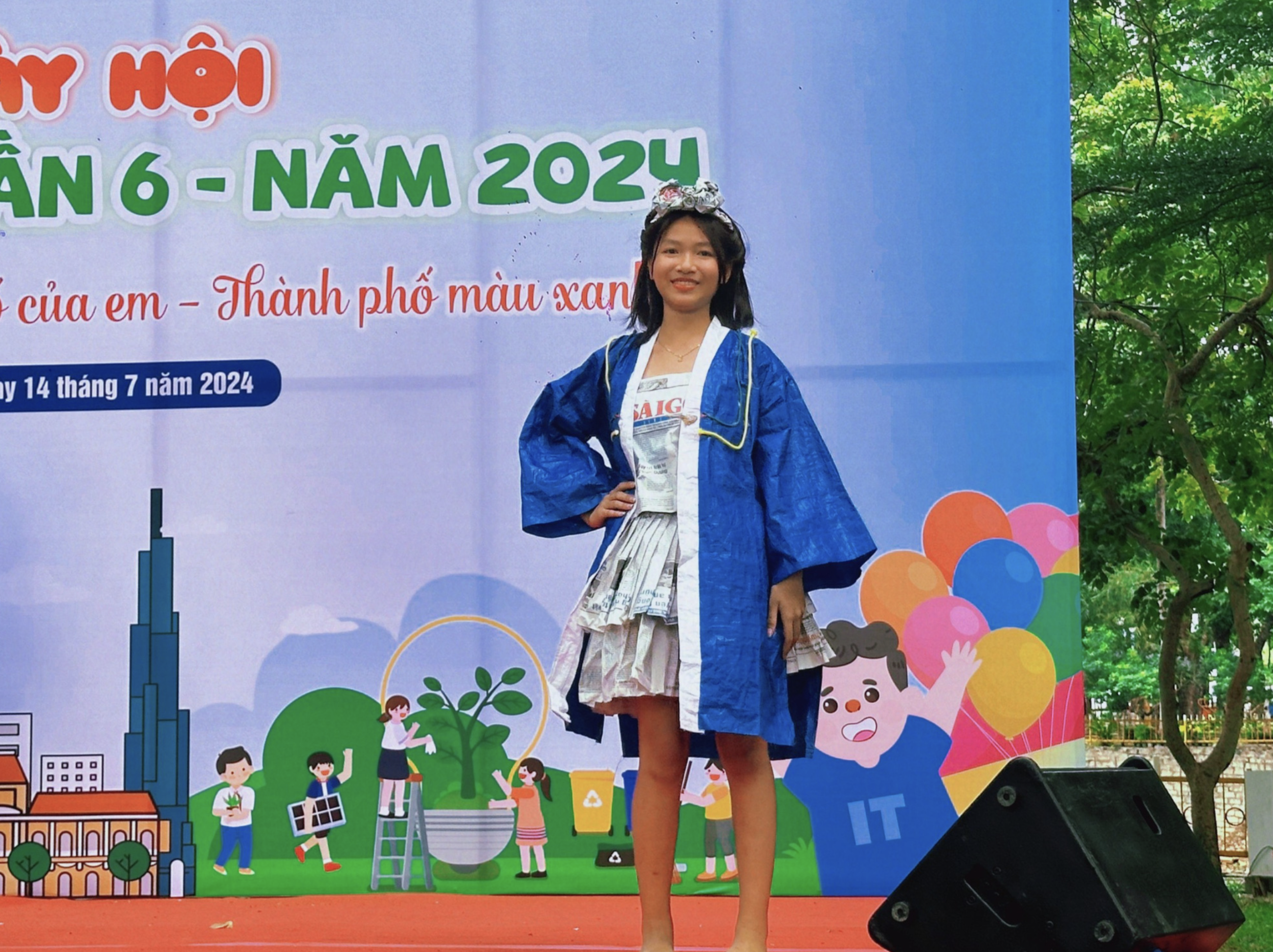 Children in Tan Dinh District, Ho Chi Minh City bring an outfit made out of old newspapers to a fashion contest. Photo: Supplied