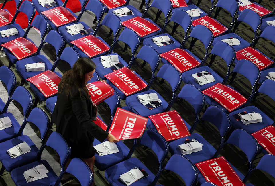 [13/16]A person walks among seats with signs in support of Republican presidential candidate and former U.S. President Donald Trump on Day 1 of the Republican National Convention (RNC) at the Fiserv Forum in Milwaukee, Wisconsin, U.S., July 15, 2024. Photo: Reuters