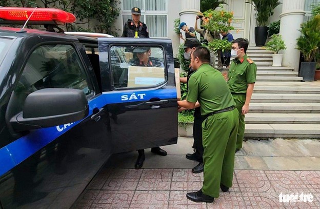 Police officers move many boxes from Loan’s residence. Photo: Ngoc Khai / Tuoi Tre