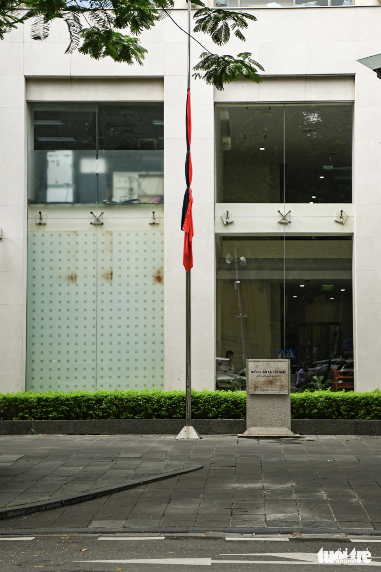 The national flag is flown at half-mast in front of the headquarters of the Vietnam News Agency. Photo: Hong Quang / Tuoi Tre