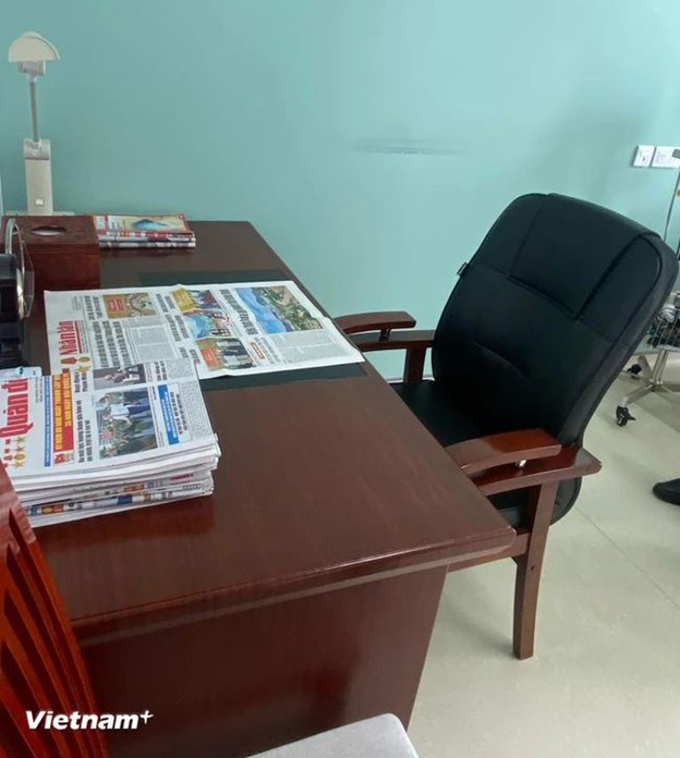 On his working desk, newspapers are arranged neatly.