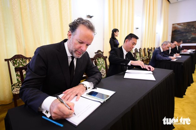 The consul general of the Netherlands in Ho Chi Minh City writes in the condolence book for Party General Secretary Nguyen Phu Trong. Photo: Quang Dinh / Tuoi Tre