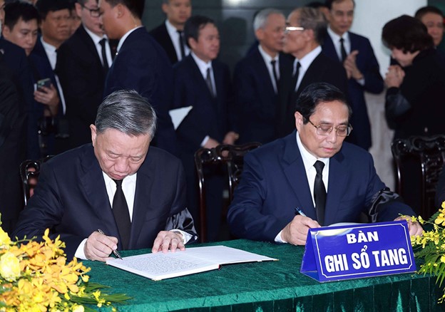 Vietnamese State President To Lam (L) and Prime Minister Pham Minh Chinh write in the condolence book for Party General Secretary Nguyen Phu Trong. Photo: Vietnam News Agency