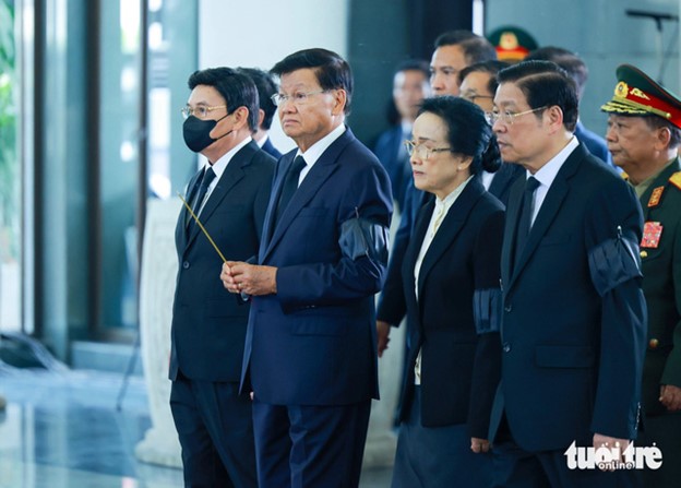 Lao Party General Secretary and President Thongloun Sisoulith (L, 2nd) and his spouse Naly Sisoulith (L, 3rd) attend the respect-paying ceremony for Party General Secretary Nguyen Phu Trong in Hanoi, July 25, 2024. Photo: Nguyen Khanh / Tuoi Tre