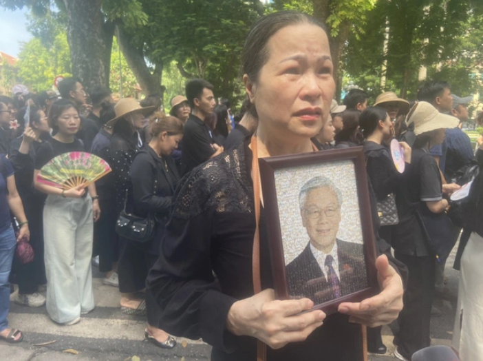 Pham Thi Thai An, a Hanoi resident, brings a portrait of Party General Secretary Nguyen Phu Trong to the National Funeral Hall on July 26, 2024. She said she had made an altar for late President Ho Chi Minh and another for late General Vo Nguyen Giap, a Vietnamese war hero, at her house, and she now wanted to make an altar for Party General Secretary Nguyen Phu Trong. Photo: T.Dieu / Tuoi Tre