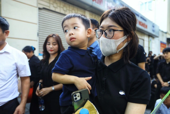 Hanh, a resident in Dong Da District, Hanoi, and her two-year-old son, began queuing up from 5:00 am on July 26, 2024 in front of the National Funeral Hall in Hanoi. Photo: Quynh Trang / Tuoi Tre