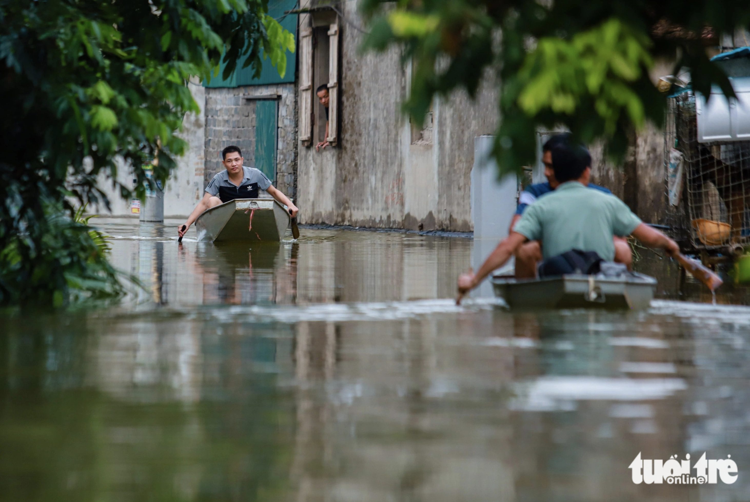 Residents use boats for commuting due to flooding in Hanoi. Photo: Quang Vien / Tuoi Tre