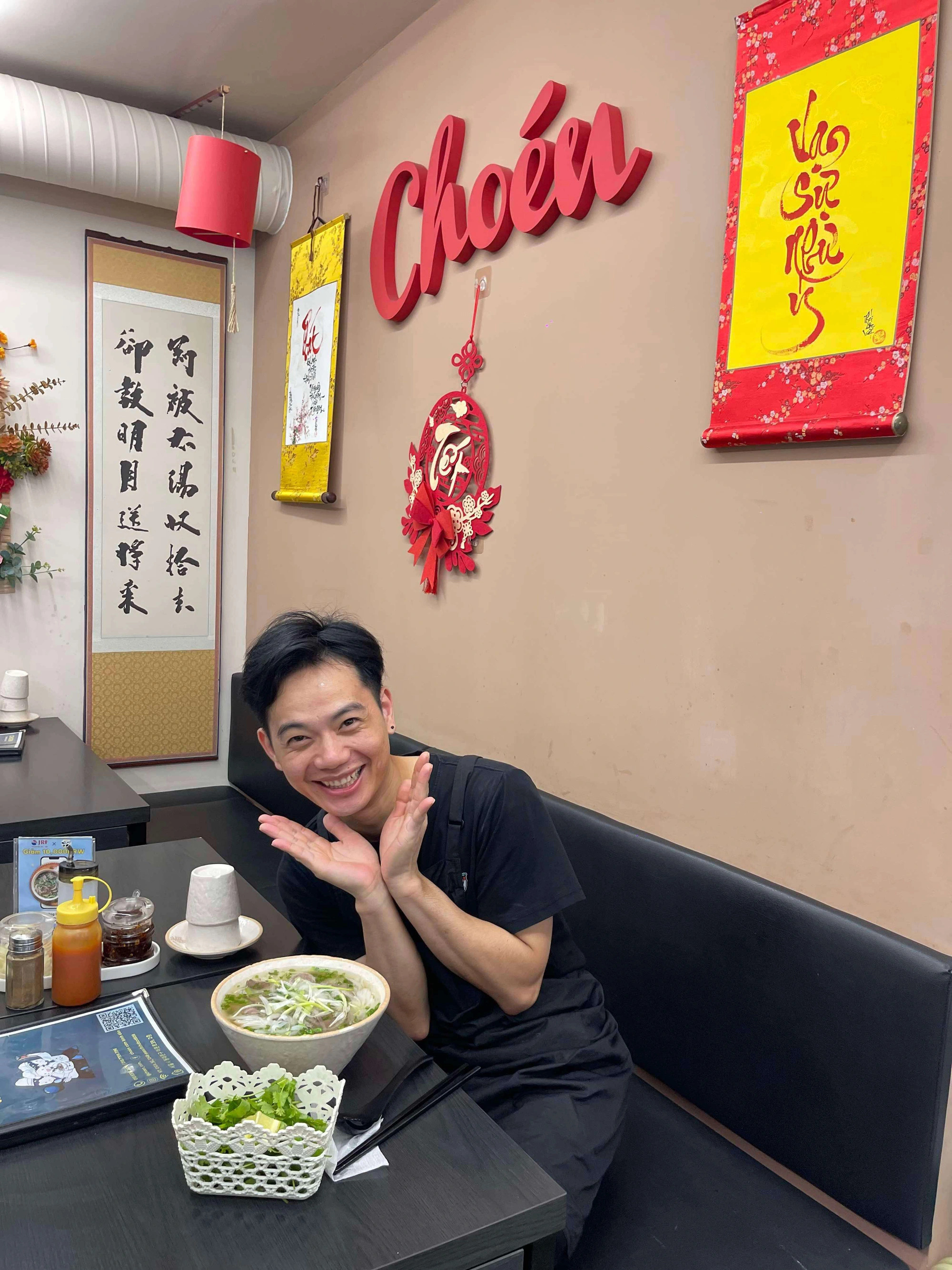 A diner poses next to a bowl of phở at a Vietnamese food establishment in Seoul, South Korea. Photo: Yen