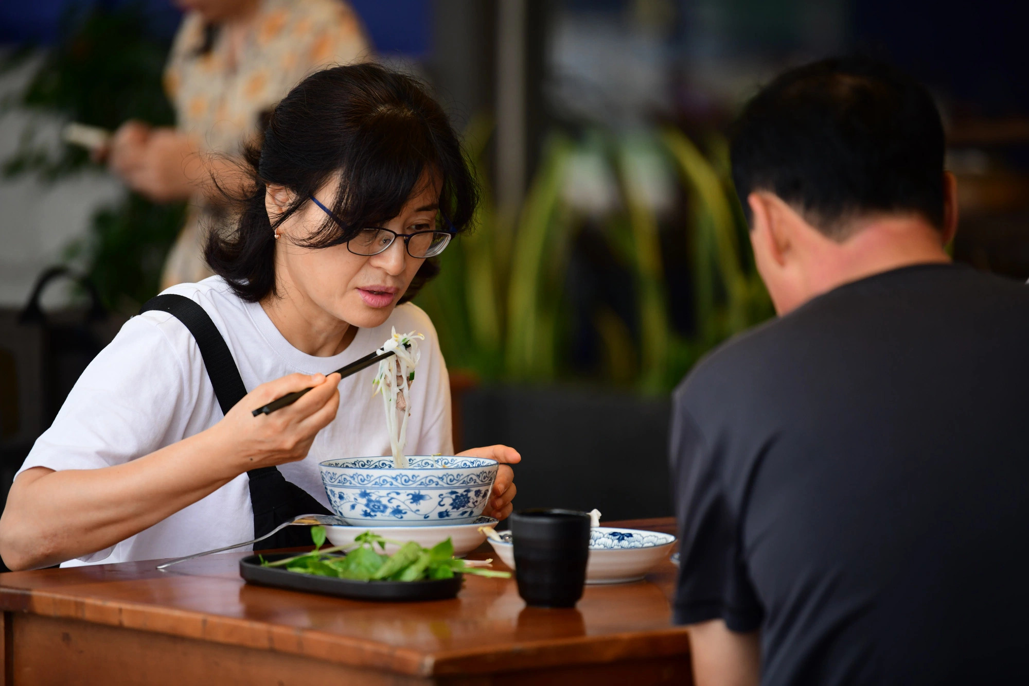 A South Korean woman enjoys a bowl of phở in Ho Chi Minh City. Photo: Quang Dinh / Tuoi Tre