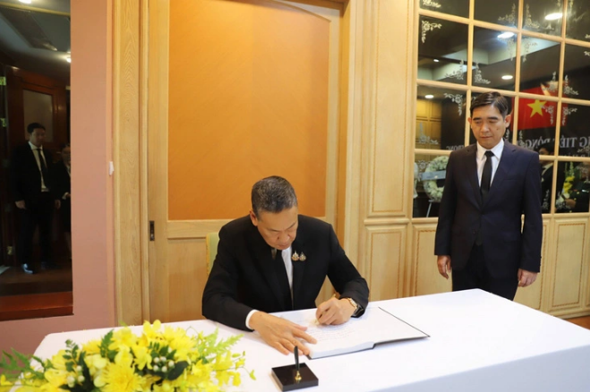 Prime Minister of Thailand Srettha Thavisin (sitting) writes in the condolence book for Vietnamese Party General Secretary Nguyen Phu Trong at the Vietnamese Embassy in Thailand. Photo: VOV