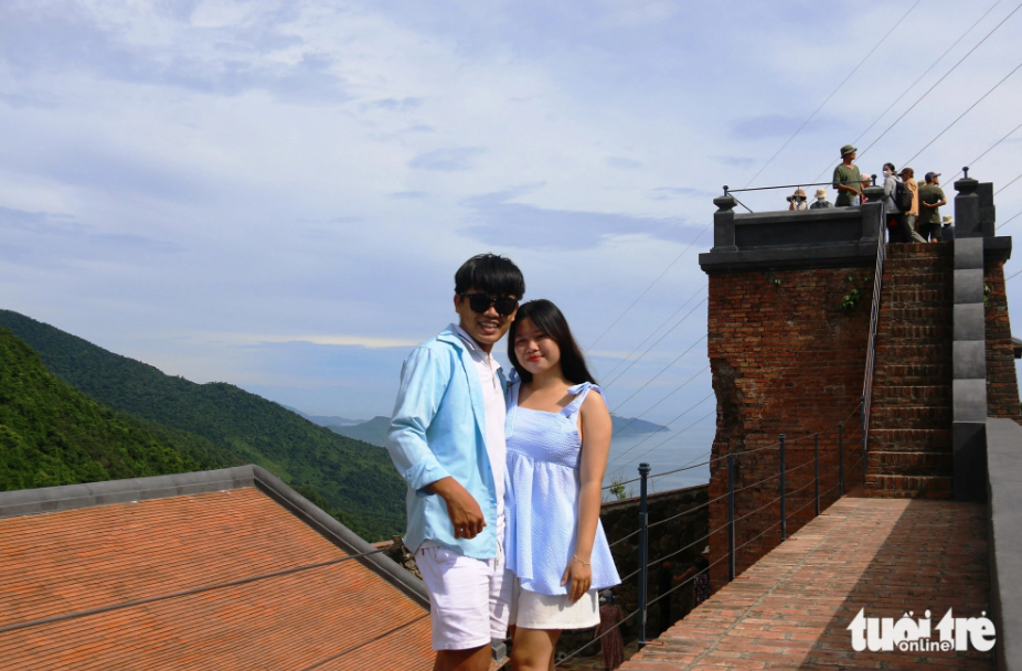 Two young people pose for a photo in the Hai Van Gate relic site. Photo: Nhat Linh / Tuoi Tre