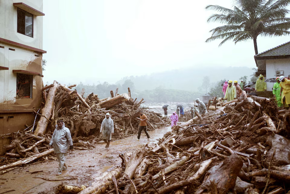 [6/6]People walk past debris at a landslide site after multiple landslides in the hills in Wayanad, in the southern state of Kerala, India, July 30, 2024. Photo: Reuters