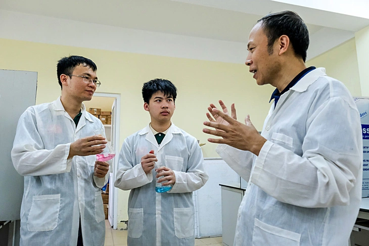 Giap Vu Son Ha (C), a 12th grader at Bac Giang High School for Gifted Students in Bac Giang Province, northern Vietnam is seen listening to instructions from his teachers in a lab. Photo: Ha Quan / Tuoi Tre