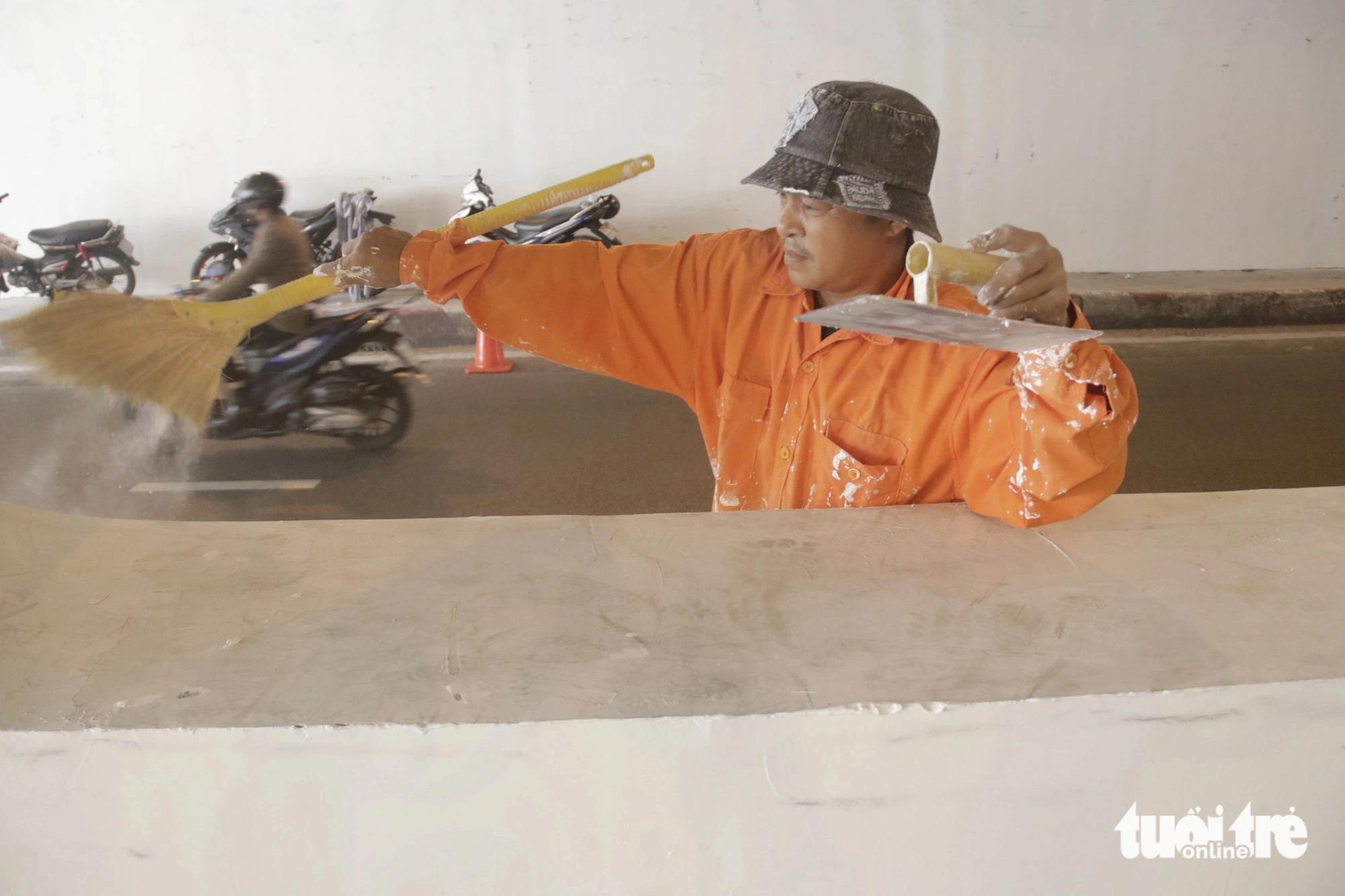 A worker is seen cleaning graffiti off the Nguyen Huu Canh underpass in Binh Thanh District, Ho Chi Minh City, August 5, 2024. Photo: Tien Quoc / Tuoi Tre