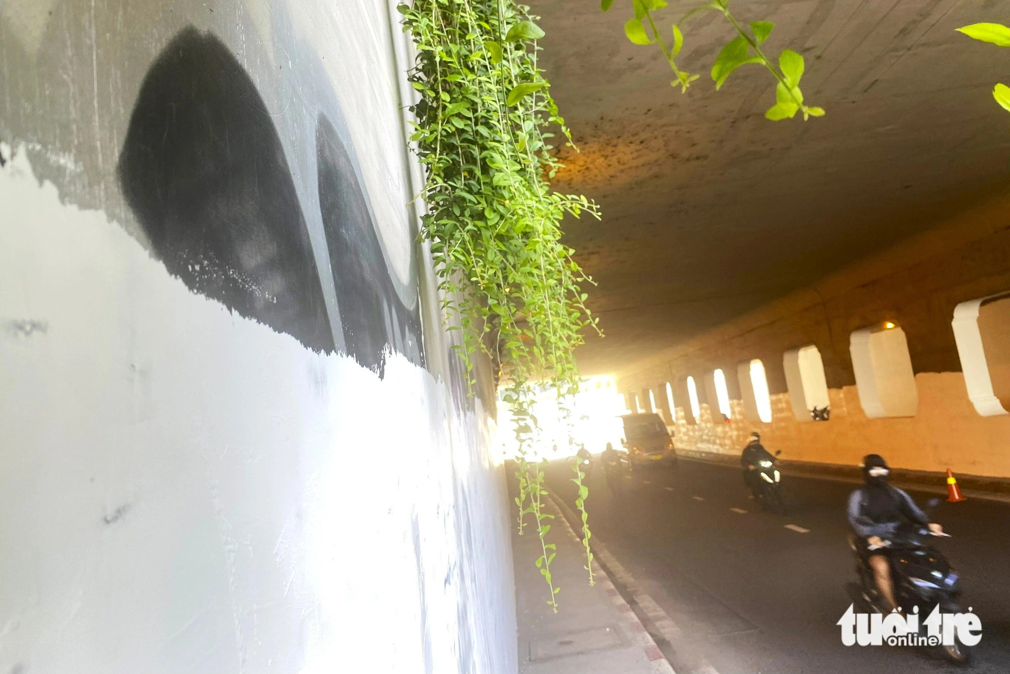 A large piece of graffiti is being removed from a wall of the Nguyen Huu Canh underpass in Binh Thanh District, Ho Chi Minh City, August 5, 2024. Photo: Tien Quoc / Tuoi Tre