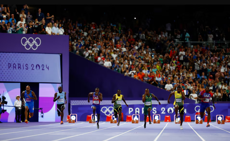 Paris 2024 Olympics - Athletics - Men's 100m Final - Stade de France, Saint-Denis, France - August 04, 2024. Noah Lyles of the United States, Kishane Thompson of Jamaica and Fred Kerley of the United States in action with athletes during the race. Photo: Reuters