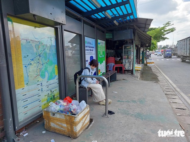 N.T.T., 22, a resident in Ho Chi Minh City, waits for a bus at a station near Nong Lam University where a styrofoam box full of trash is put. She said “I don’t understand why this box is placed at the bus stop.” Photo: Dinh Khai / Tuoi Tre