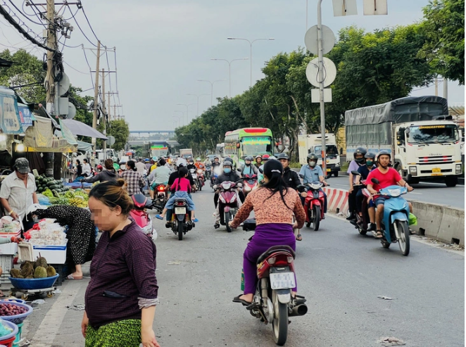 Residents ride motorbikes in the wrong direction, even wear no helmets, in front of the Thu Duc Wholesale Market in Thu Duc City, under Ho Chi Minh City. Photo: Xuan Doan / Tuoi Tre