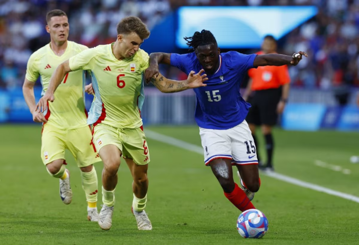 Paris 2024 Olympics - Football - Men's Gold Medal Match - France vs Spain - Parc des Princes, Paris, France - August 09, 2024. Bradley Locko of France in action with Pablo Barrios of Spain. Photo: Reuters