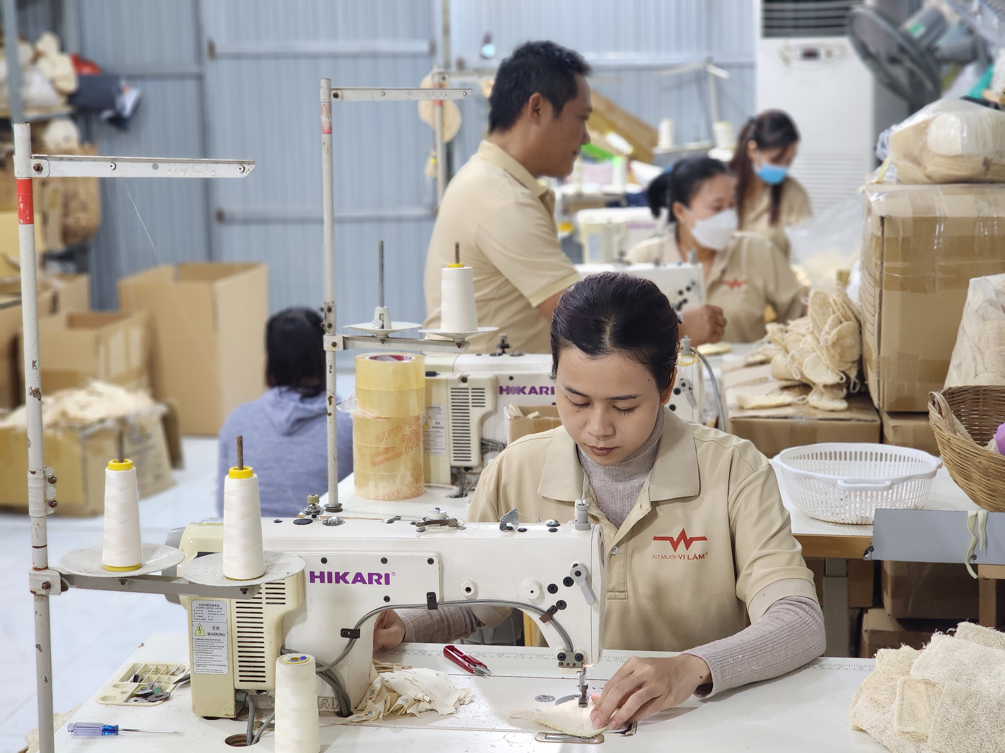 Workers sew the loofah pieces into finished products. Photo: Ngoc Phuong / Tuoi Tre News