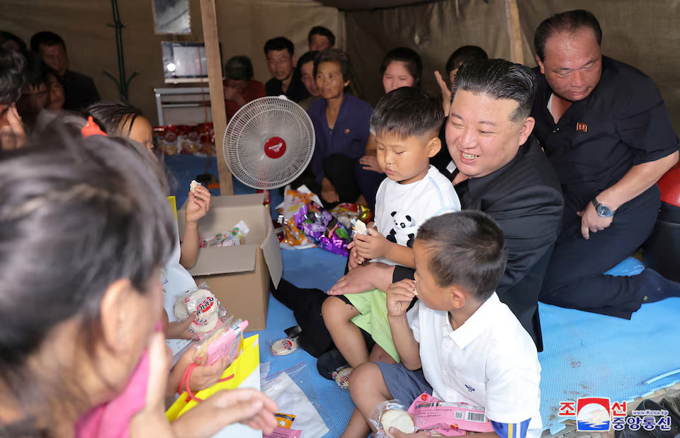 [3/6]North Korean leader Kim Jong Un carries a child as he sits with a family inside a tent during a visit to the flood-affected area of Uiju County, North Pyongan Province, North Korea, in this photo released August 10, 2024. Photo: Reuters