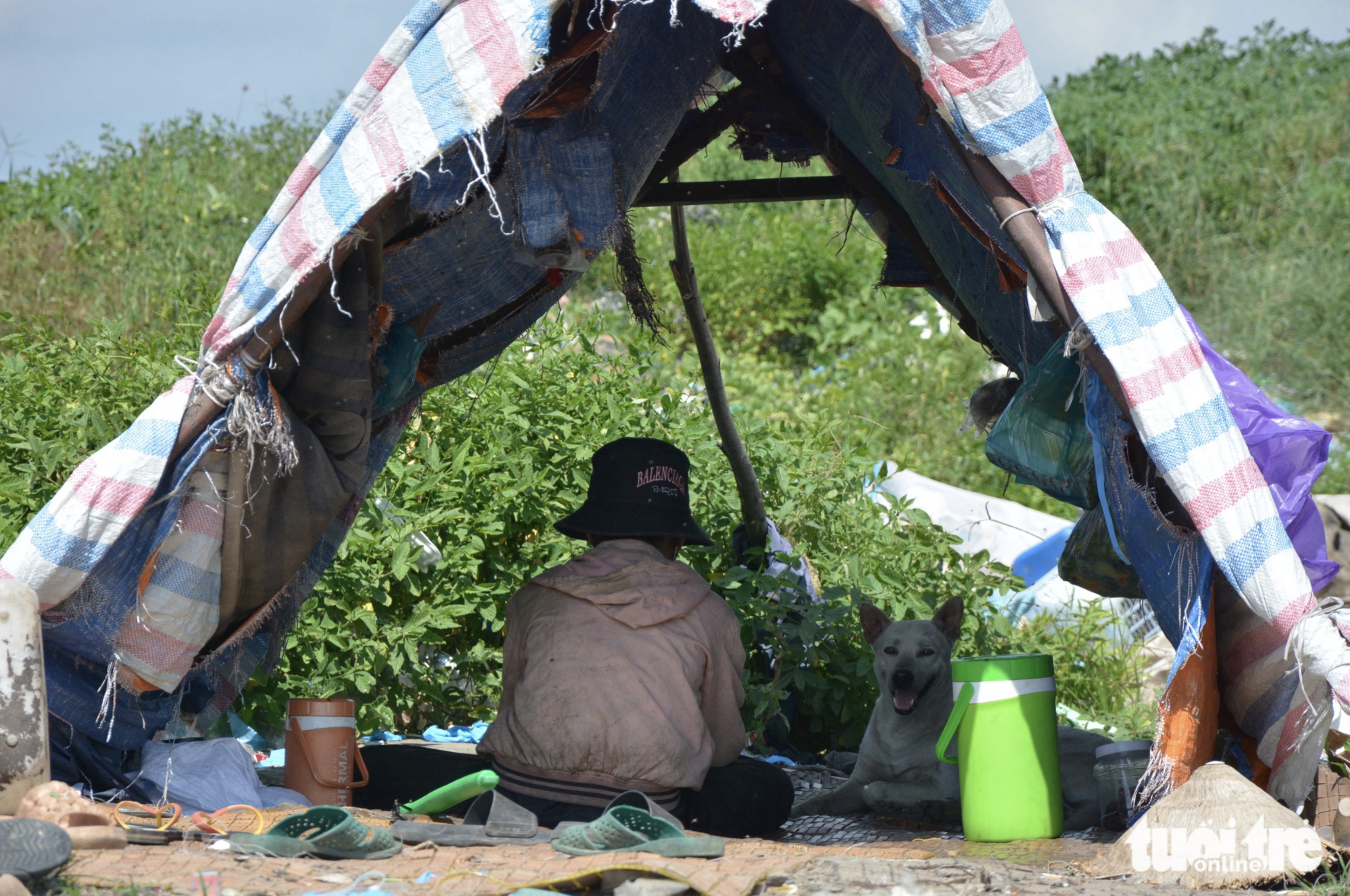 A ragpicker takes a rest in a tent erected at Binh Tu Landfill. Photo: Duc Trong / Tuoi Tre