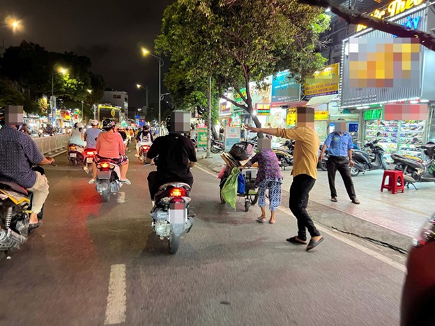 An employee of a clothing store on Hau Giang Street in District 6, Ho Chi Minh City solicits passers-by. Photo: An Vi / Tuoi Tre