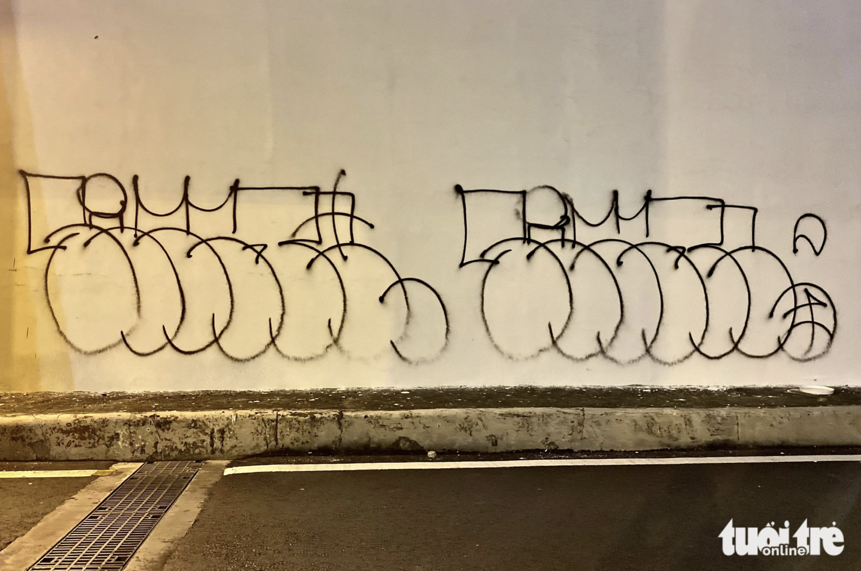 Within less than one hour, graffiti appears on a wall of Nguyen Huu Canh Underpass in Binh Thanh District, Ho Chi Minh City. Photo: Ksor Quy / Tuoi Tre