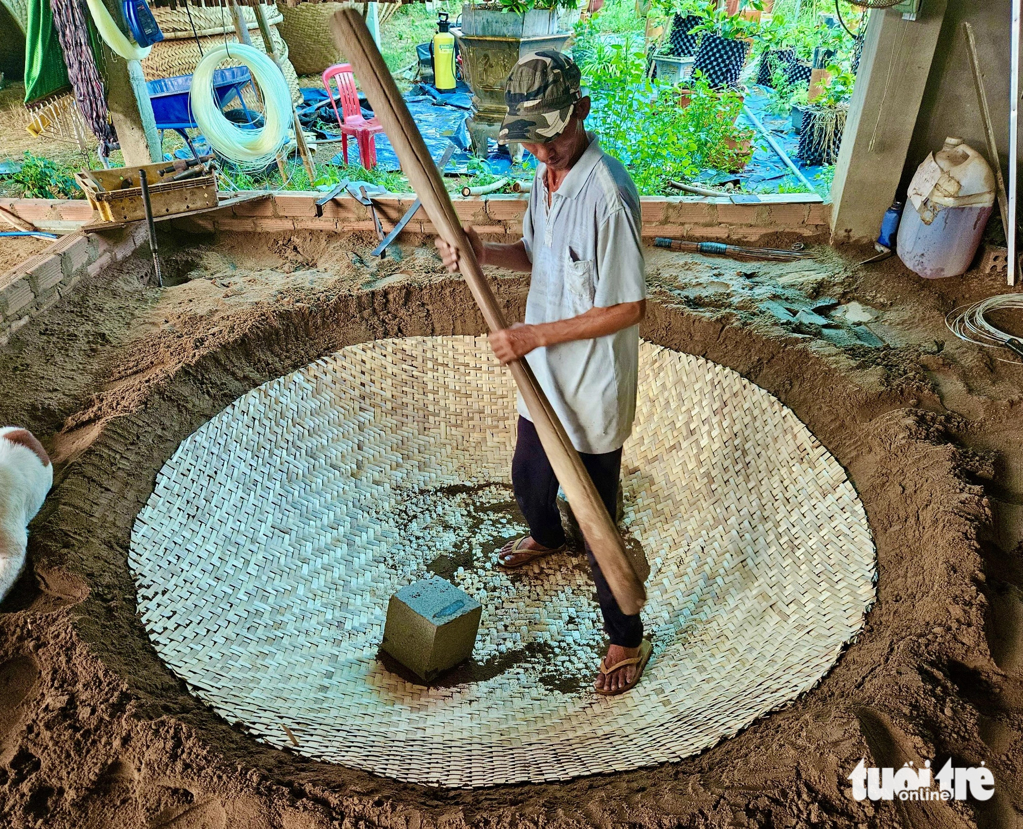 Truong Van Trung shapes a basket boat bottom at Phu My basket boat craft village in Tuy An District, Phu Yen Province, south-central Vietnam. Photo: Minh Chien / Tuoi Tre