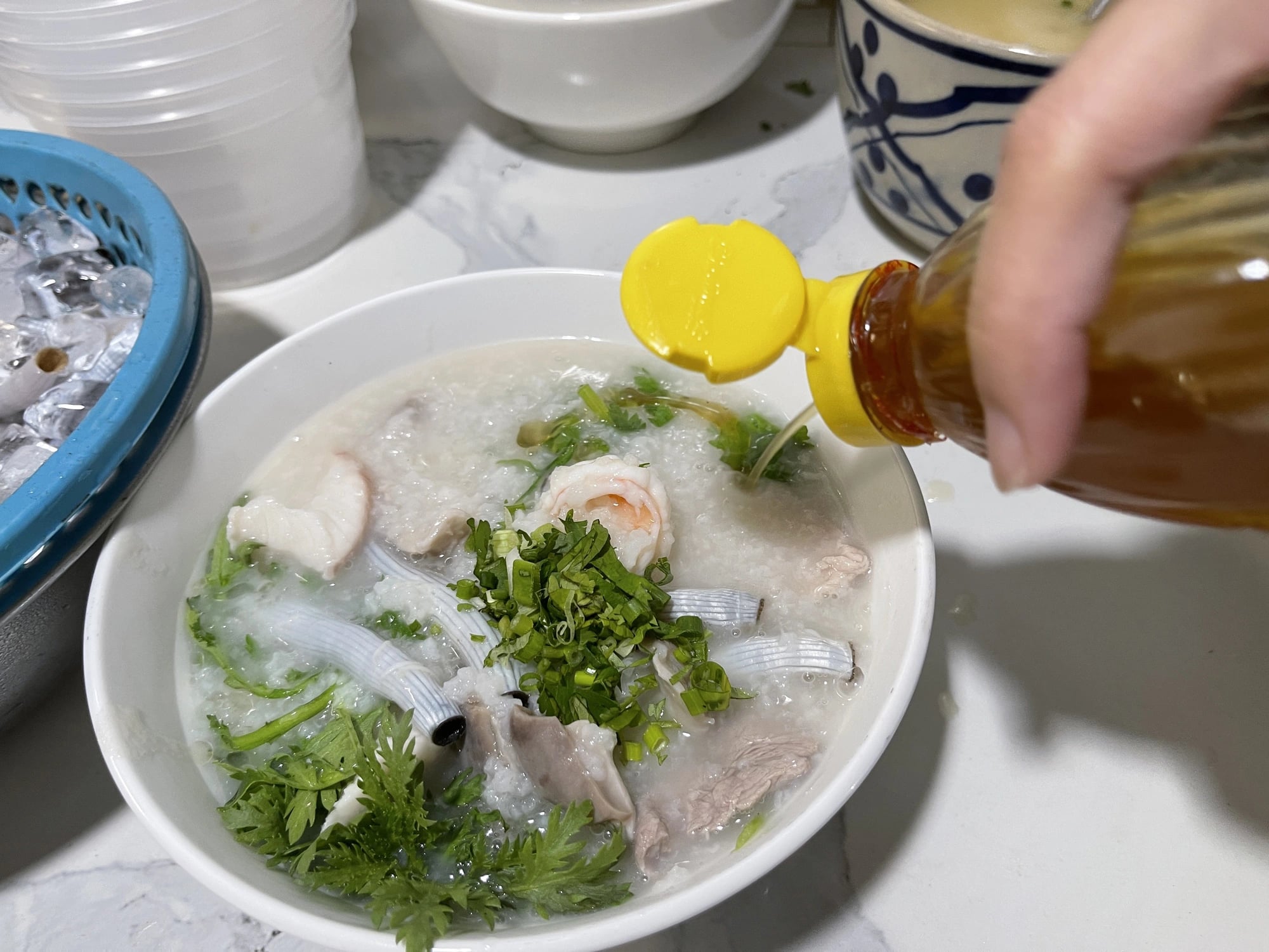 A bowl of Teochew porridge is added with sesame oil before being served at a 40-year-old shop in Tan Phu District, Ho Chi Minh City. Photo: Dong Nguyen / Tuoi Tre News