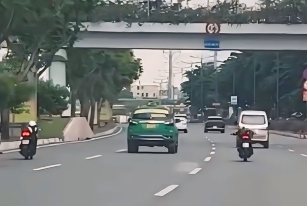 A screenshot indicates two young men lying on two motorbikes' seats and running in a lane for cars on Pham Van Dong Boulevard in Go Vap District, Ho Chi Minh City.