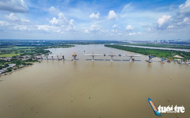 Workers, engineers, and building materials are transported to the construction site through the Dong Nai River. Photo: Duc Phu / Tuoi Tre