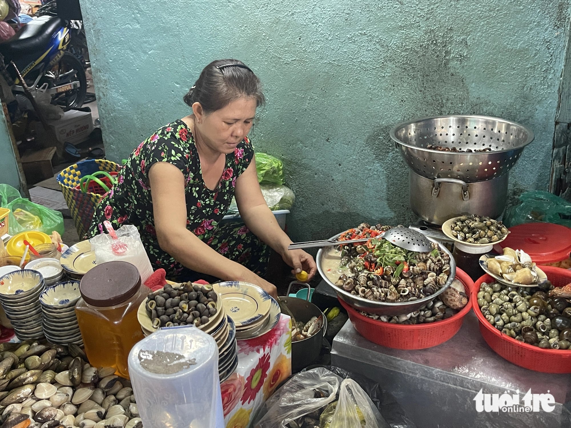 Thuong prepares shellfish dishes at her stall in an alley inside Vuon Chuoi Market in District 3, Ho Chi Minh City. Photo: Dong Nguyen / Tuoi Tre News